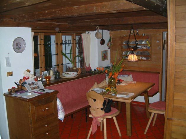 Küche mit Eckbank und rotem Fliesenboden