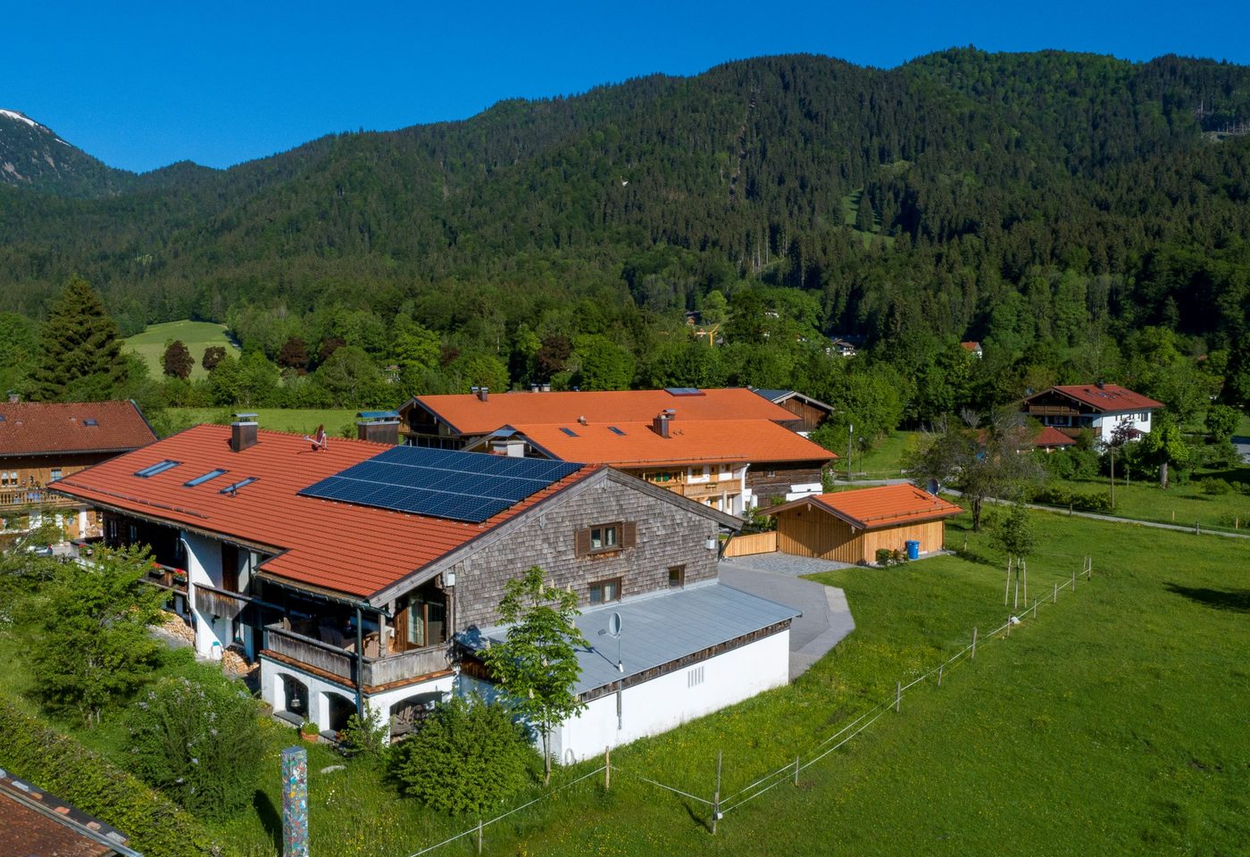 Luftaufnahme des Hofs mit Solardach, Garagen und Wiesen