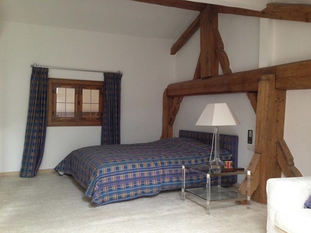 Schlafzimmer mit Holzbalken und Doppelbett